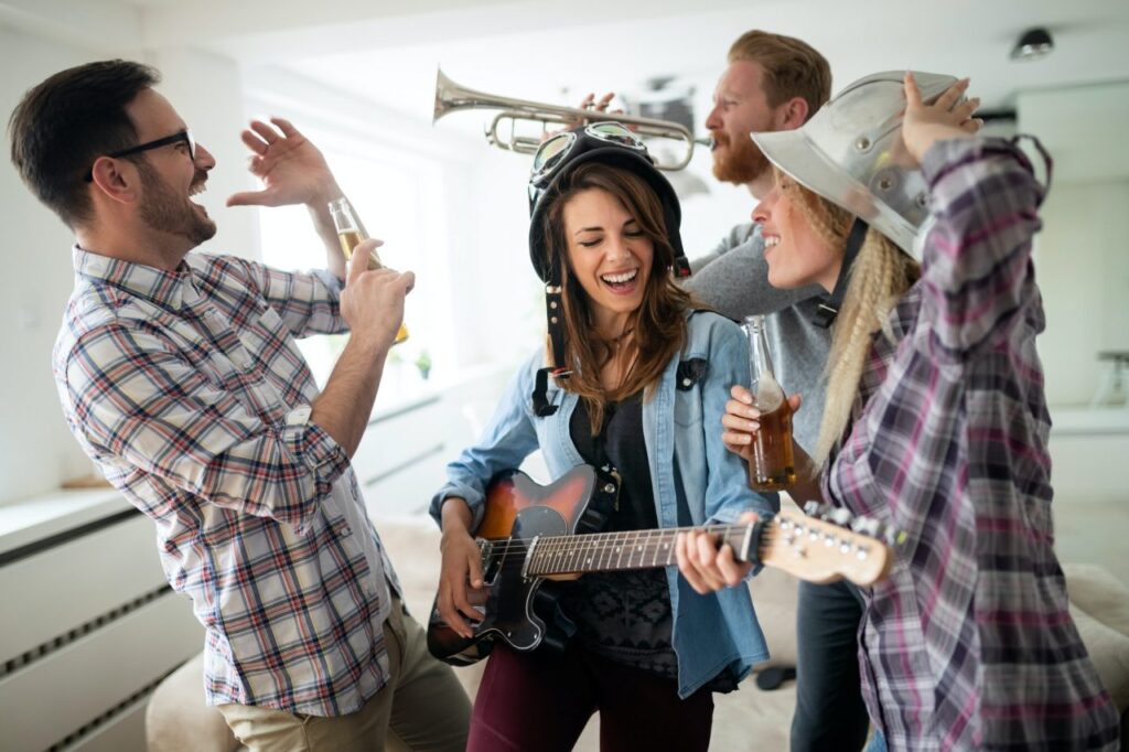 Friends having fun and partying in house and playing music